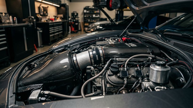 Kit d’admission en carbone dans le compartiment moteur d’une voiture préparée